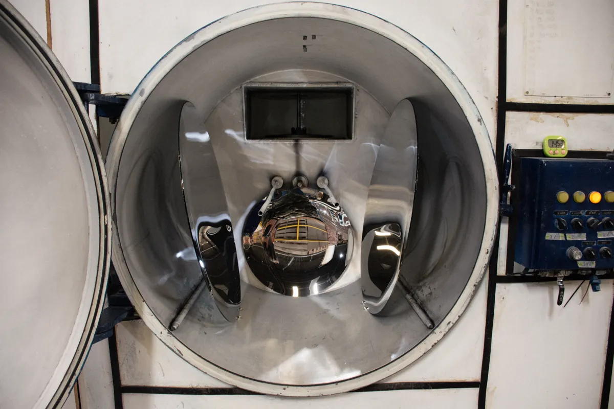 La cámara de alto vacío abierta, con un reflector recién metalizado con terminación de espejo